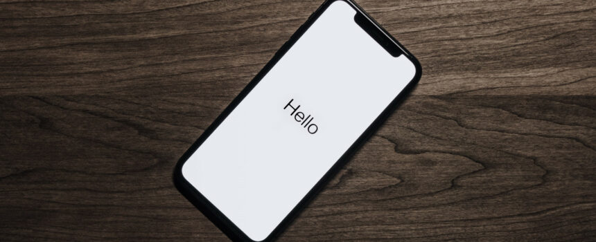 iPhone on table showing Hello