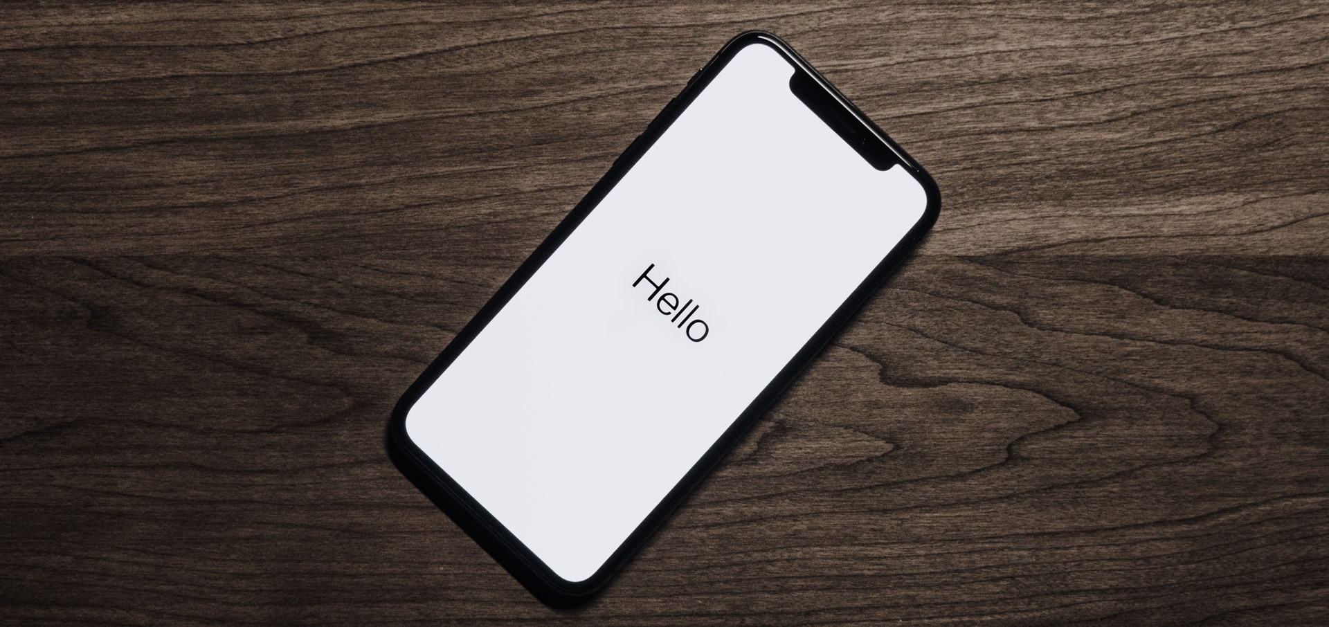 iPhone on table showing Hello