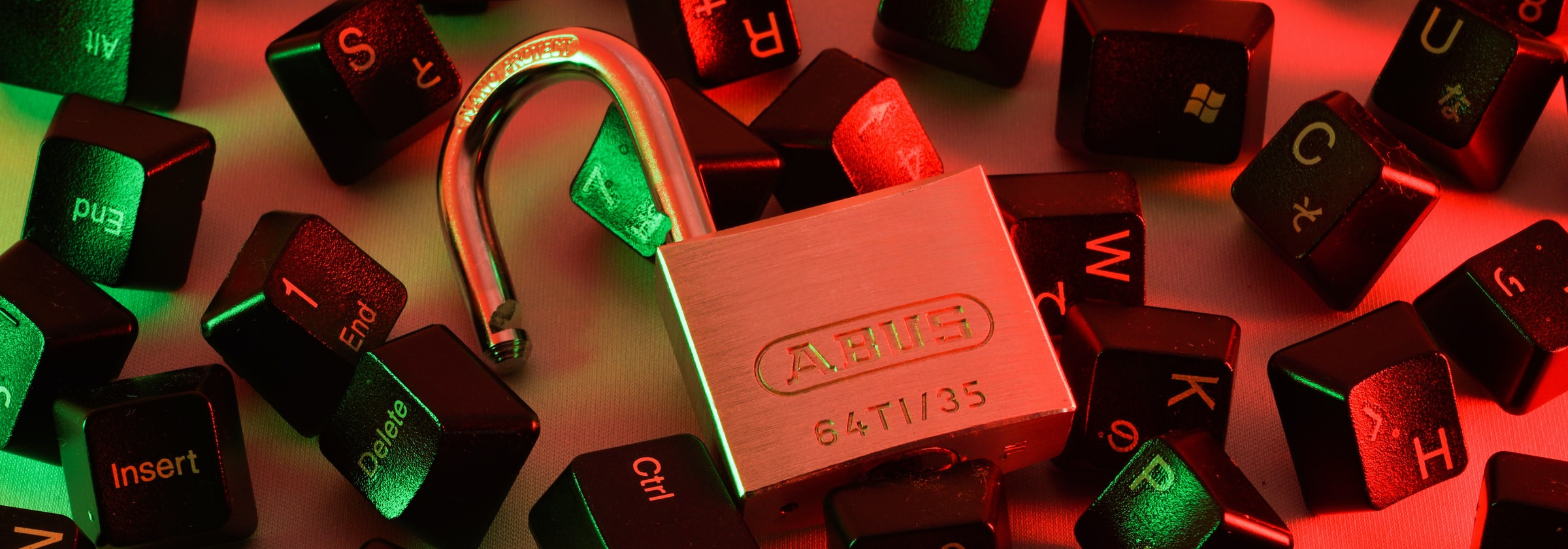 Open lock with various computer keys on a desk